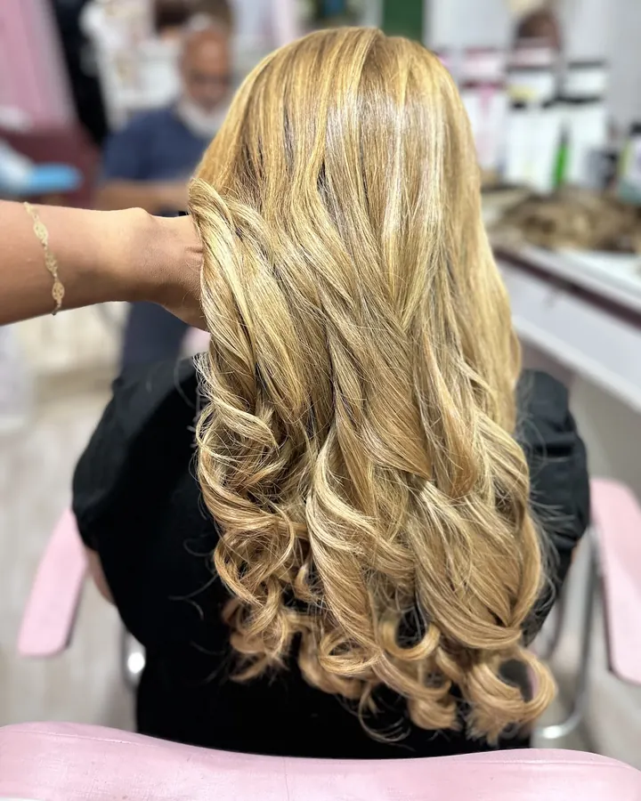 Cabelo loiro longo com cachos largos, finalizado no studio