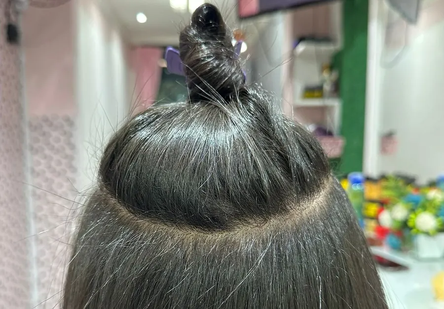 Cabelo preso no alto mostrando a nuca e a linha de aplicação das mechas